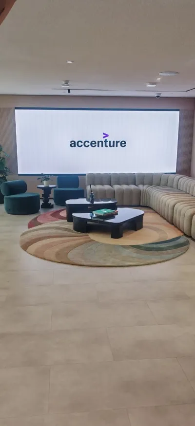 Lounge with a large LED display showing the Accenture logo