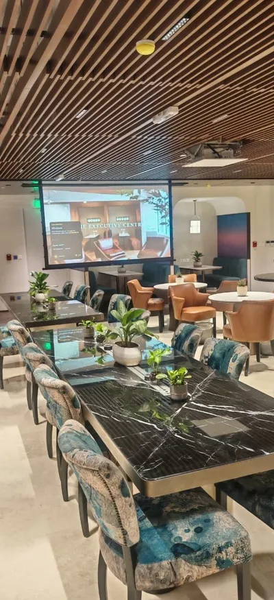 Lounge with a projection screen under a wood-slat ceiling
