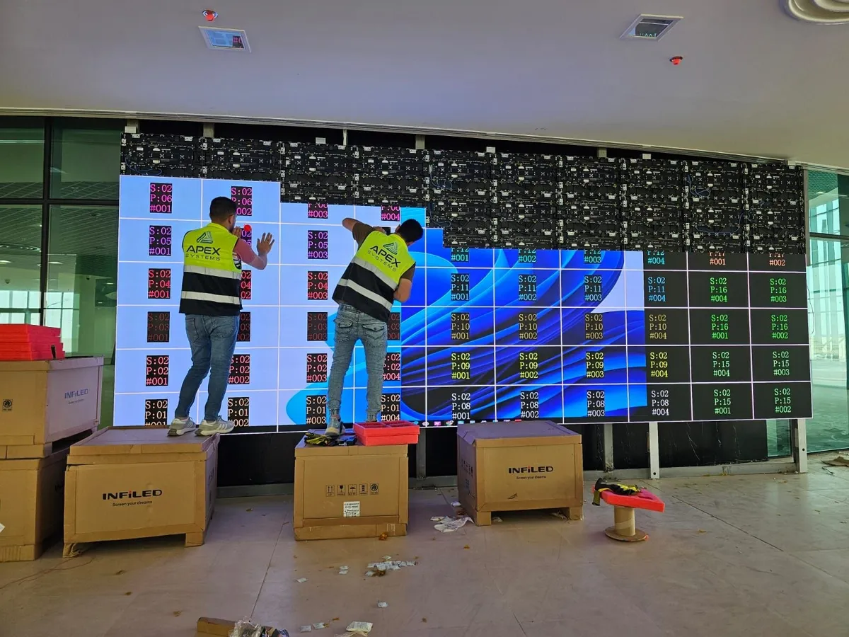 Two Apex technicians commissioning an LED wall