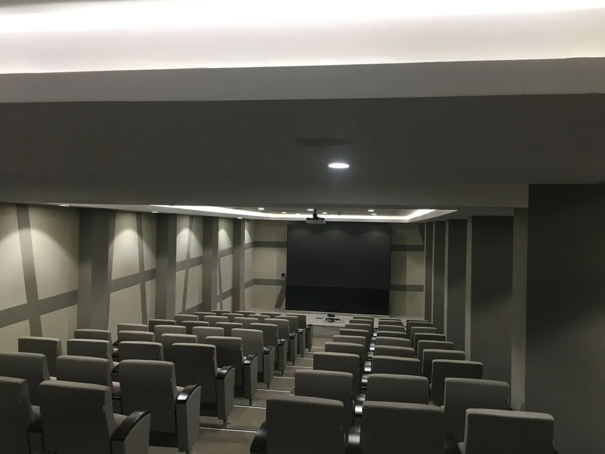 Training room with a ceiling speaker and projection screen