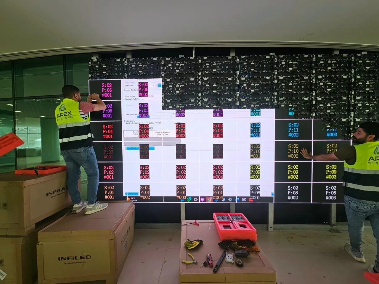 Technicians calibrating the LED wall, with a test pattern on screen