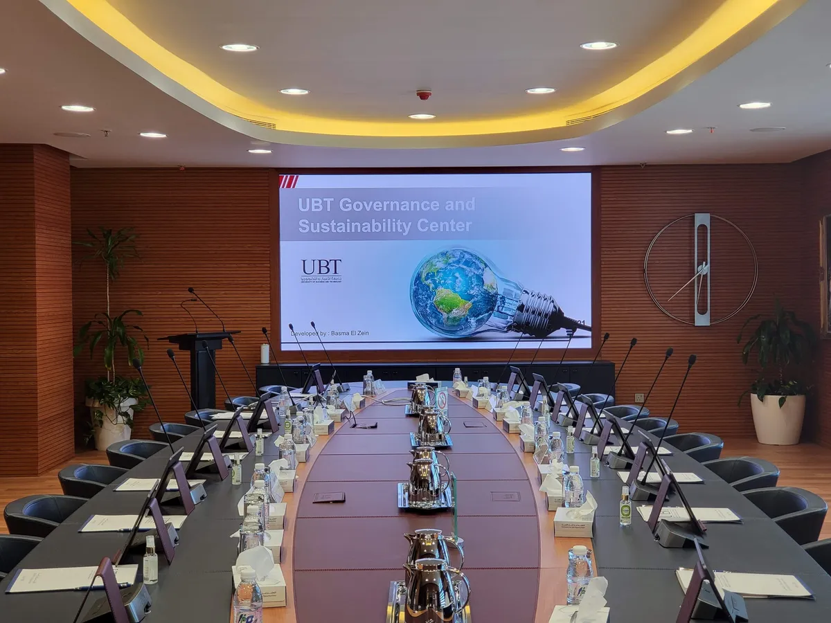 Boardroom set for a meeting, with the LED wall showing a presentation