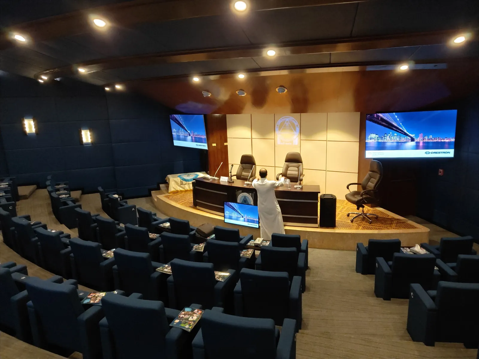 Ibn Mahfouz auditorium with a stage, side screens and tiered seating