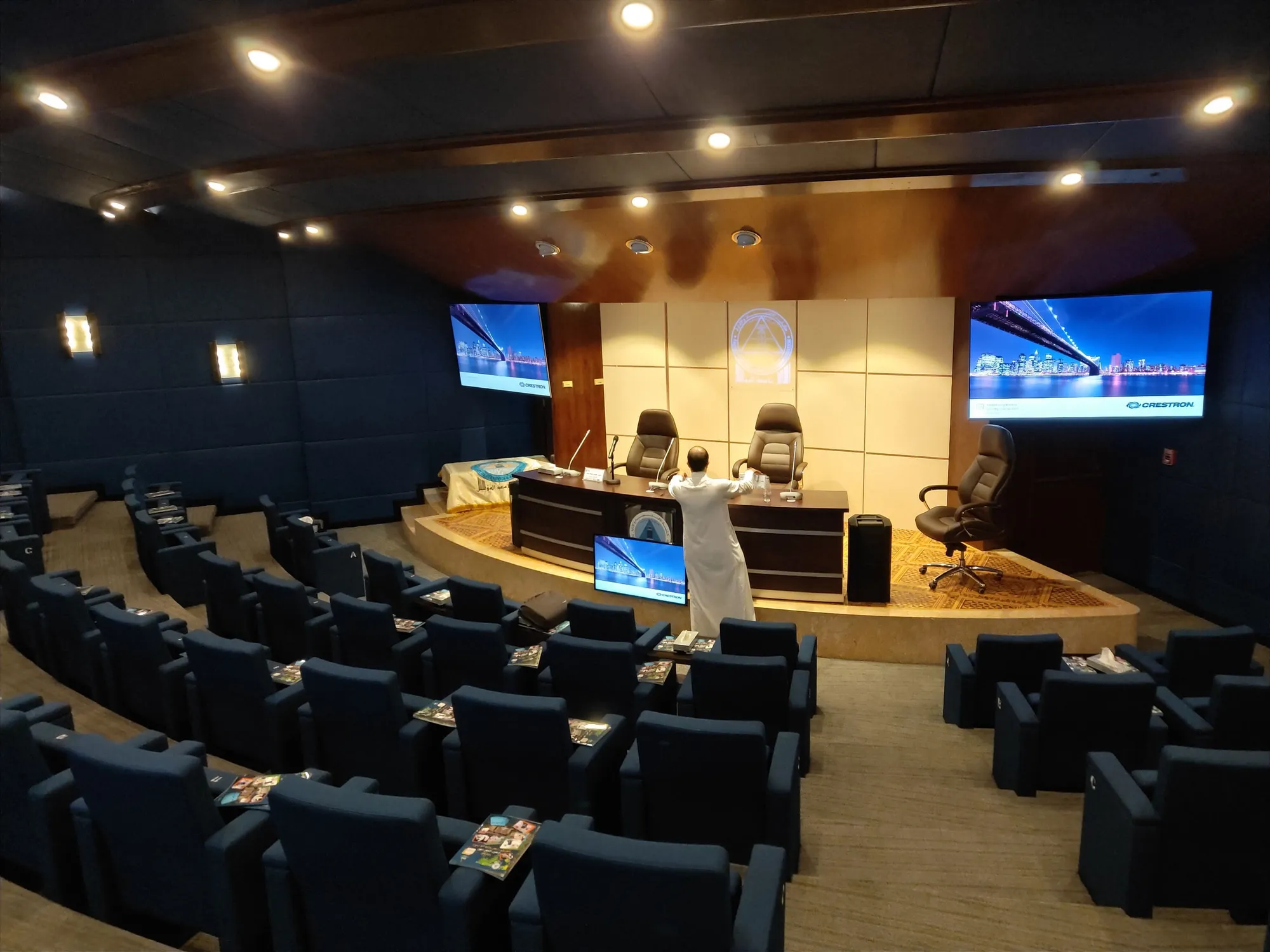 Ibn Mahfouz auditorium with a stage, side screens and tiered seating