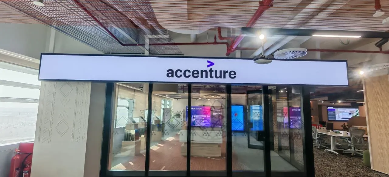 Accenture sign above a glazed lounge with LED displays