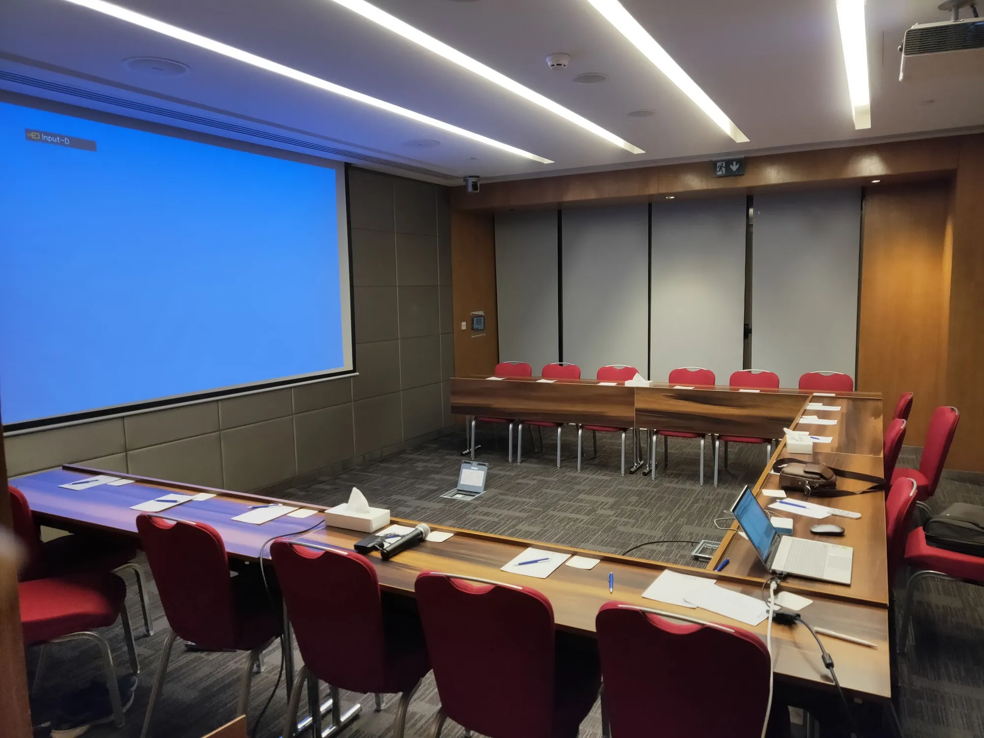 Meeting room with a large screen and a U-shaped table