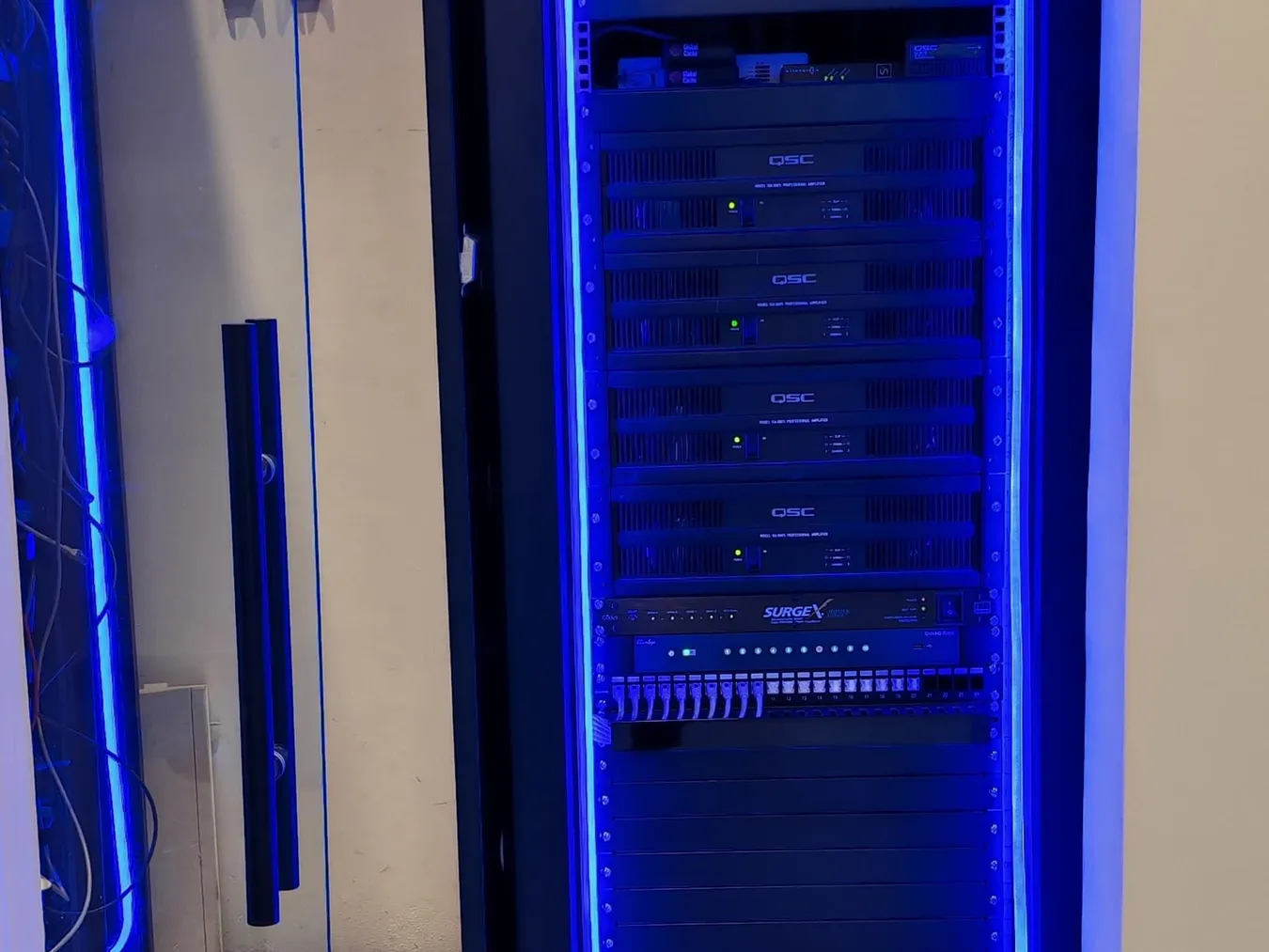 Equipment rack lit in blue inside a technical niche