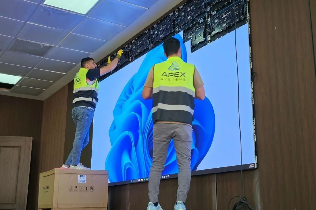Two Apex Systems technicians commissioning an LED wall